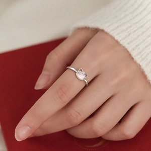 S925 silver cat-shaped ring with pink opal stone on a woman's finger, minimalist style
