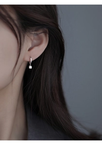 Close-up of a model wearing the S925 silver geometric cube drop earring in a minimalist style