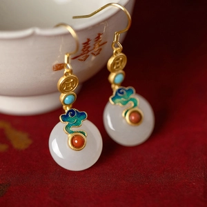 Detailed macro view of Chinese style jade earrings with blue enamel clouds and gold coins