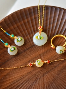 Macro view of Chinese style jade jewelry set including lotus necklace and enamel earrings