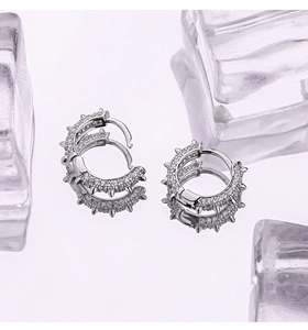 Macro shot of silver spike hoop earrings with CZ pavé and a punk-style stud detail