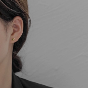 Close-up of minimalist S925 silver stud earring with olive green marquise stone on ear