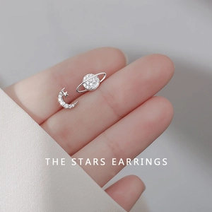 Close-up of asymmetrical s925 silver moon and planet stud earrings with zircon inlay