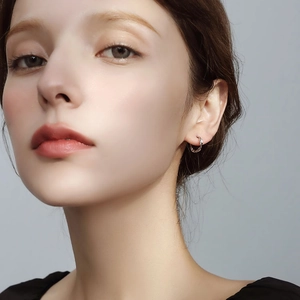 Elegant S925 sterling silver twisted hoop earrings worn by a model in a minimalist style
