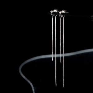 Boucles d'oreilles minimalistes en argent S925 avec pampilles élégantes sur fond noir profond