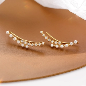 Detailed view of elegant gold ear climbers featuring white pearls and zircon stones