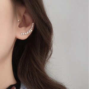 Detail of curved ear crawler featuring alternating white pearls and micro rhinestones