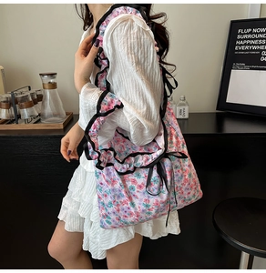 Floral canvas tote bag with black ruffle trim and bow detail shown on a model