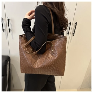 Gros plan détaillé de la texture tressée marron d'un grand cabas aux accents dorés