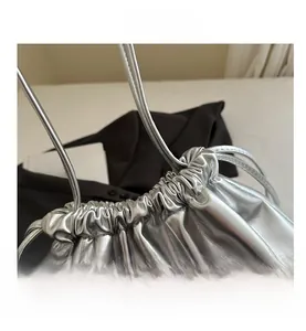 Détail du sac seau métallisé argenté avec cuir brillant et texture plissée élégante