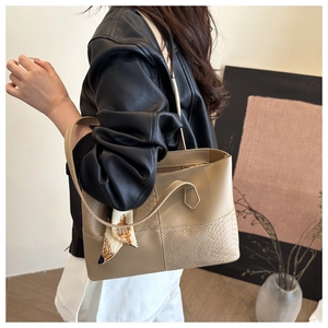 Detail of beige tote bag with snakeskin texture and decorative vintage silk scarf accent