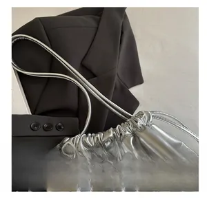 Détail du sac seau métallisé argenté avec une texture en cuir souple et cordon serrage