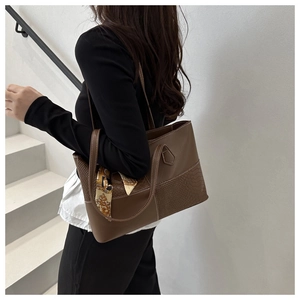 Detail of brown tote bag with snake pattern leather and decorative vintage silk scarf
