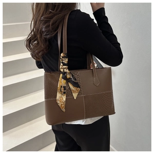 Detail view of large brown crocodile pattern tote bag with vintage scarf on the handle