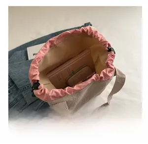 Top view of beige drawstring bucket bag interior showing large capacity and pink lining