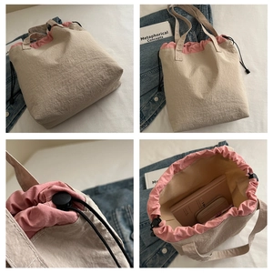Detail view of large nylon tote bag with drawstring closure and pink contrast lining