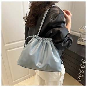 Détail du sac plissé bleu clair avec boucle nœud en métal et fermeture par cordon serrage