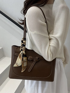 Classic dark brown leather tote bag with silk scarf accessory and contrast stitching
