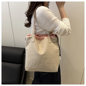 Detail view of canvas tote bag with pink drawstring closure and two-tone stylish design