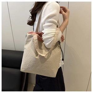 Close-up of beige canvas tote bag with pink drawstring lining and lightweight texture