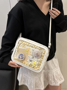 Sac Itabag blanc en cuir PU avec fenêtre transparente et pin's porté par un modèle