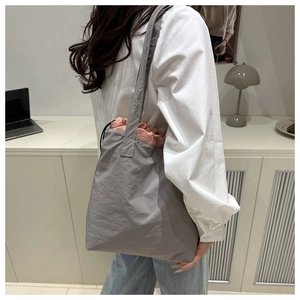 Detail of grey canvas tote bag with pink drawstring closure for daily commuting