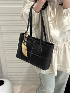 Black crocodile embossed tote bag with decorative silk scarf and white stitching detail