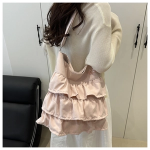 Detail of pink layered ruffle tote bag featuring a pleated design and minimalist label