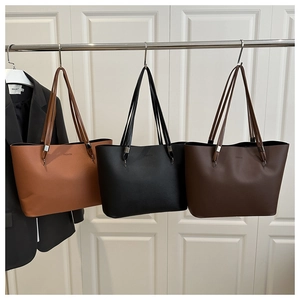 Vue détaillée de trois grands sacs cabas en cuir en marron, noir et café foncé