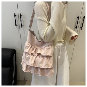 Detail of light pink tote bag featuring multi-layer ruffled design and satin finish