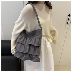 Close-up of dark grey canvas tote bag featuring stylish triple-layered ruffle pleats