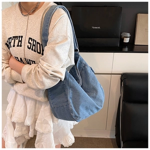 Détail du sac hobo en denim bleu délavé avec poche latérale spacieuse et texture vintage douce