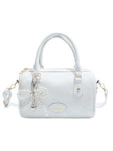 White Boston handbag with textured leather and pearl bow charm accessory in a front view