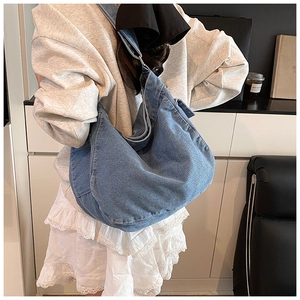 Side view of large washed denim hobo bag worn by model for high capacity visual display