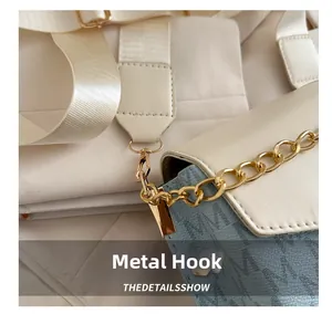 Primer plano del gancho metálico dorado y el diseño grabado en el bolso bandolera casual
