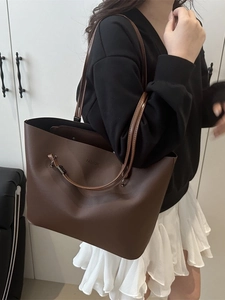 Large brown leather tote bag with FASHION embossing shown on a model for daily commute