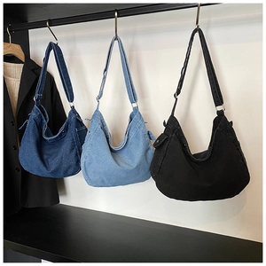 Minimalist denim hobo bags in dark blue, light blue and black on boutique display