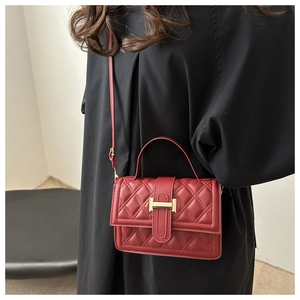 Detailansicht der roten Stepptasche mit goldener H-förmiger Metallschnalle für Damen