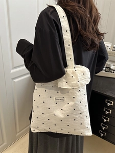 White ruffled chiffon tote bag with black polka dots and spacious interior on a model