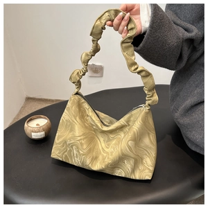 Detail der olivgrünen Handtasche mit Marmor-Textur und modisch gerafftem Schulterriemen
