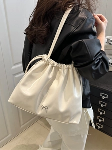 Chic off-white glossy drawstring hobo bag with silver bow detail for commute