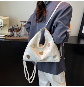 Detail der weißen Plissee-Tasche mit bunten Herz-Patches und verstellbaren Trägern