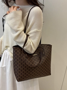 Large dark brown leather tote bag with all-over M pattern and shoulder straps