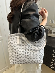 Large white tote bag with grey M pattern and Fashion label shown on a model shoulder