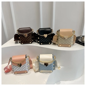 Detalle de mini bolsos bandolera de moda en cinco colores con logo y dijes de corazón