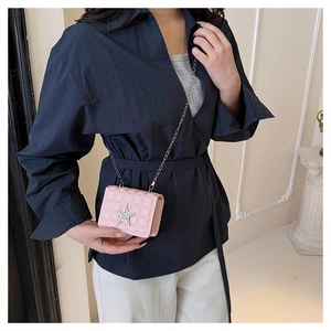 Détail du sac bandoulière rose matelassé avec étoile en strass et chaîne argentée