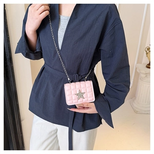 Détail d'un mini-sac rose matelassé à chaîne orné d'une étoile en diamant étincelante