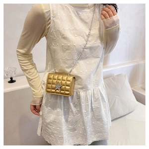 Détail du sac bandoulière matelassé doré avec boucle étoile brillante et chaîne fine