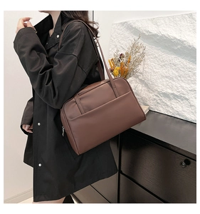 Detail view of brown leather tote bag showing spacious zipper compartment and magnetic pocket
