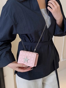 Sac à bandoulière rose matelassé avec étoile en strass porté par un mannequin